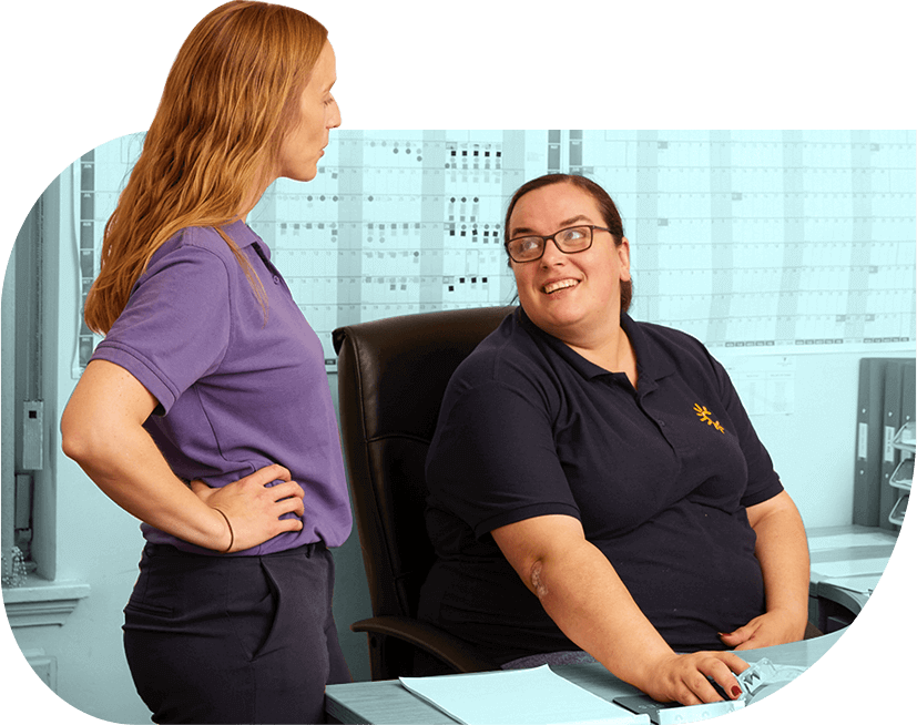 Two people smile in conversation in the office of social enterprise Radiant Cleaners.